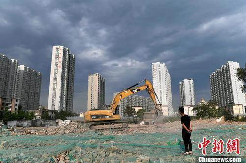 资料图：工人操作挖掘机在山西太原一商品房建设工地施工作业。<a target='_blank' href='http://www.chinanews.com/' _fcksavedurl='http://www.chinanews.com/'>中新社</a>记者 韦亮 摄