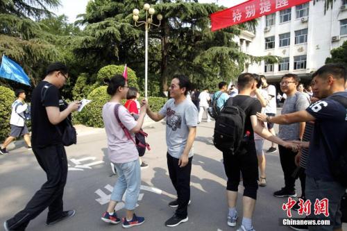 资料图：2018年6月7日，山东省实验中学考点，考生们陆续走进考场，老师为考生们加油鼓劲。<a target='_blank' href='http://www.chinanews.com/' _fcksavedurl='http://www.chinanews.com/'>中新社</a>记者 王占波 摄