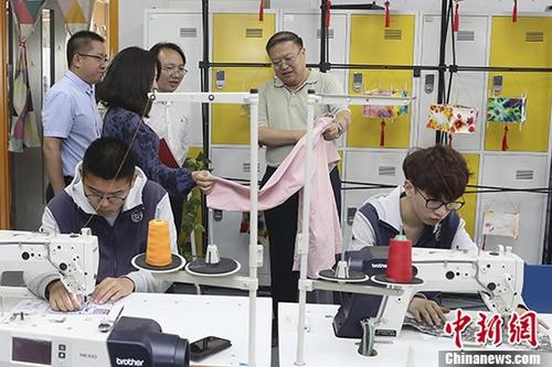 5月9日，北京劳动保障职业学院面向大众举办校园开放日活动，通过“特色课程展示”、“社团活动展示” 、“校园参观”等活动，全方位地展现高端技术技能人才贯通培养。该学院今年高端贯通项目的5个专业方向分别为人力资源管理 、社会保障、智慧养老与健康管理、智慧城市设施安全管理、智能楼宇信息技术，需要进行七年贯通培养，包括两年基础教育阶段与北京十一学校联手全面实施选课走班，三年专业教育阶段学生接受本院职业教育，最后两年的本科教育阶段由北京信息科技大学、首都经济贸易大学和首都医科大学等进行本科阶段培养。图为北京劳动保障职业学院院长李继延(右二)在开放日活动中介绍学院特色专业。
<a target='_blank' href='http://www.chinanews.com/' _fcksavedurl='http://www.chinanews.com/' _fcksavedurl='http://www.chinanews.com/'>中新社</a>记者 盛佳鹏 摄